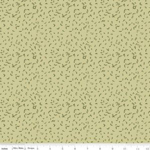 Celery green fabric with scattered tiny dark green leaf motifs with a ruler for scale along the bottom. 