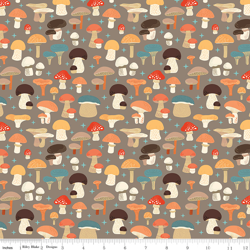 A repeating pattern of illustrated mushrooms in warm autumn colors on a taupe background, with a small ruler strip along the bottom edge showing scale.