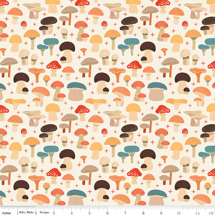A repeating mushroom pattern on a cream background, with small red plus signs between the motifs. The mushrooms are shown in muted autumn tones including orange, brown, teal-blue, and beige. Ruler for scale.