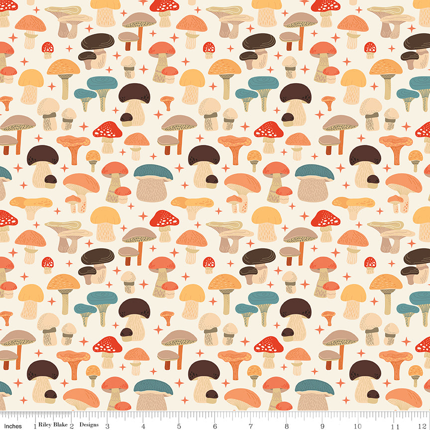 A repeating mushroom pattern on a cream background, with small red plus signs between the motifs. The mushrooms are shown in muted autumn tones including orange, brown, teal-blue, and beige. Ruler for scale.