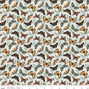 A repeating fabric pattern featuring orange, black, and yellow butterflies with blue-gray leaves on a white background, with a ruler along the bottom edge showing scale.