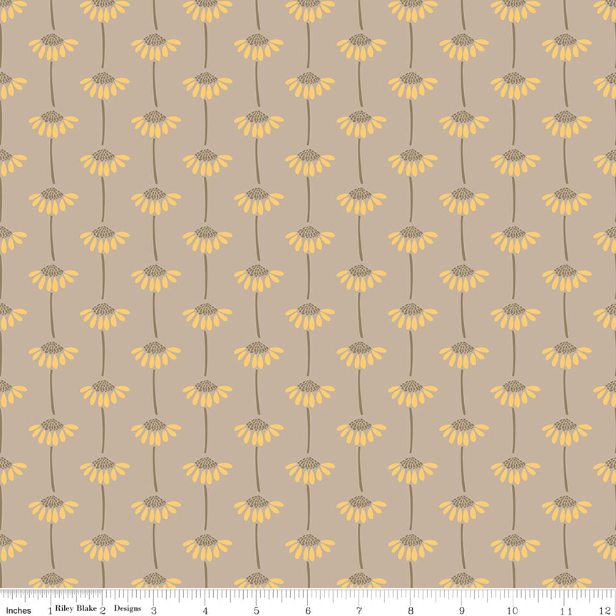 A repeating floral pattern on a warm taupe background, featuring yellow daisy-like flowers with brown centers and stems. A small ruler along the bottom for scale. 