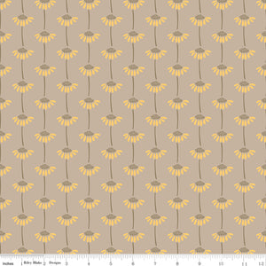A repeating floral pattern on a warm taupe background, featuring yellow daisy-like flowers with brown centers and stems. A small ruler along the bottom for scale. 