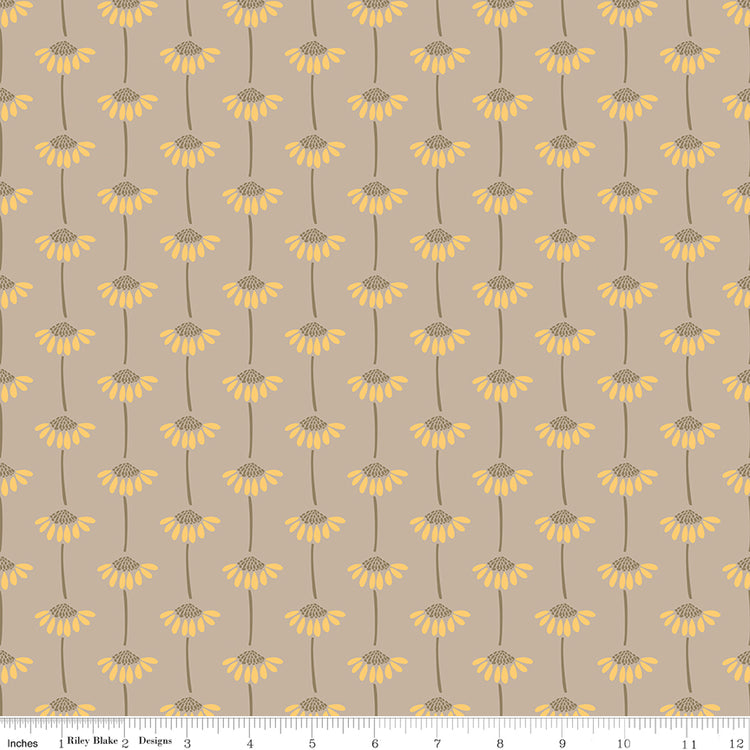 A repeating floral pattern on a warm taupe background, featuring yellow daisy-like flowers with brown centers and stems. A small ruler along the bottom for scale. 
