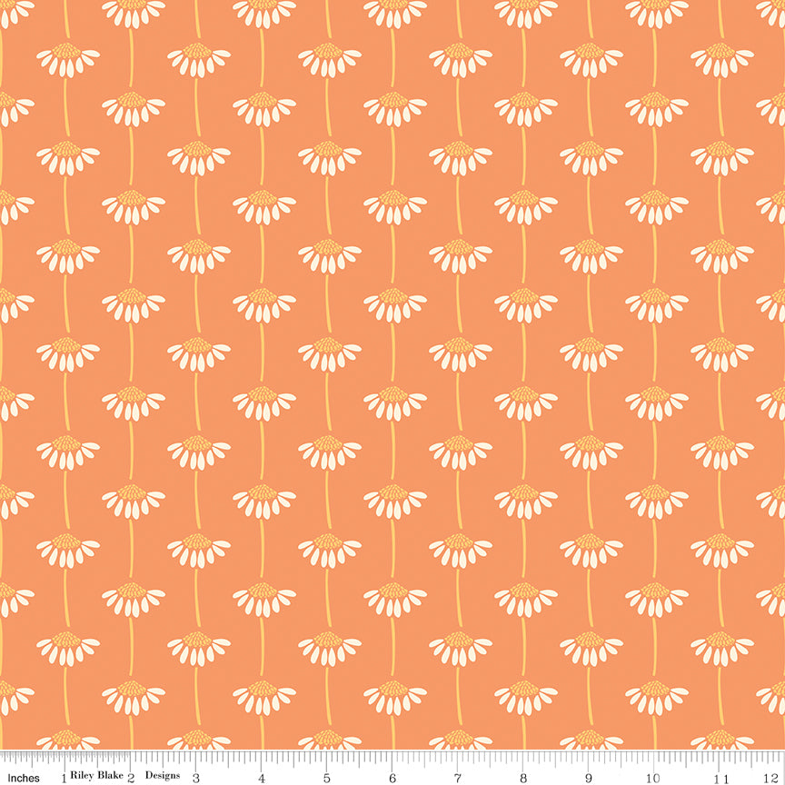 Fabric with small white floral pattern on an orange background. Ruler along the bottom for scale. 