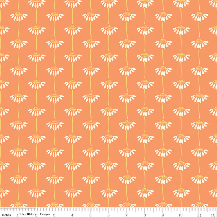 Fabric with small white floral pattern on an orange background. Ruler along the bottom for scale. 