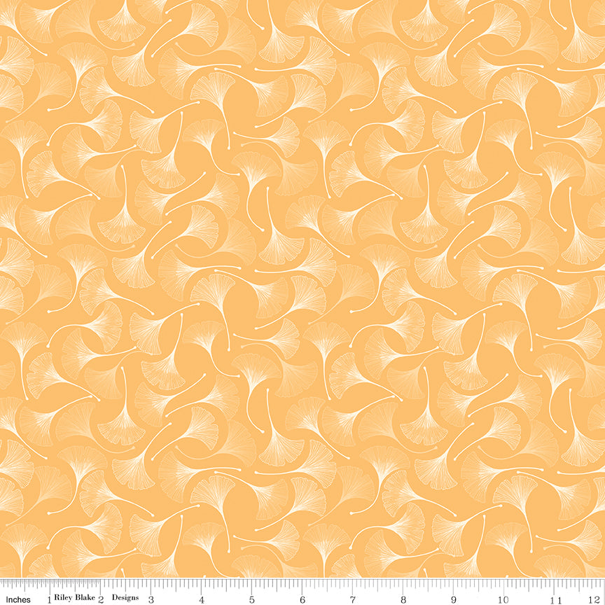 A repeating pattern of white ginkgo leaves on a warm peach-orange background, shown as a fabric or wallpaper design with a ruler at the bottom indicating scale.