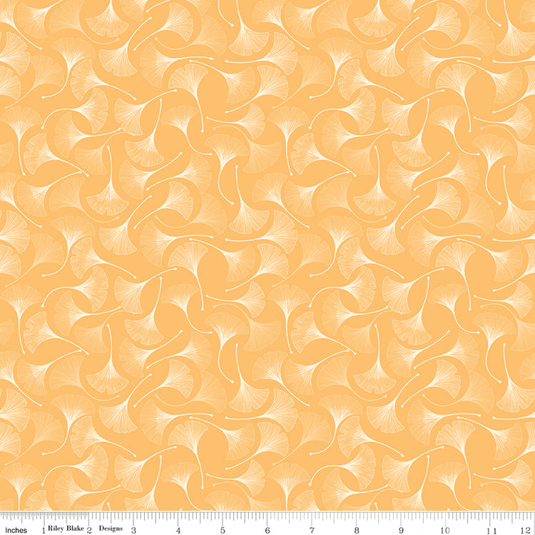 A repeating pattern of white ginkgo leaves on a warm peach-orange background, shown as a fabric or wallpaper design with a ruler at the bottom indicating scale.