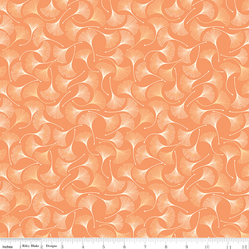 A repeating pattern of stylized ginkgo leaves in peach, orange, and cream, shown as a fabric or paper swatch with a ruler along the bottom for scale.