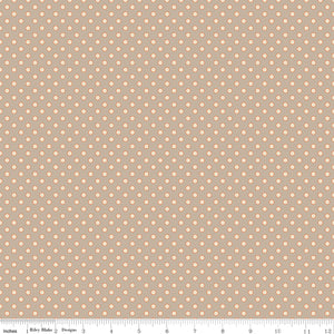 A repeating fabric pattern of small peach-colored dots on a warm taupe background, with a measuring ruler along the bottom edge showing scale.
