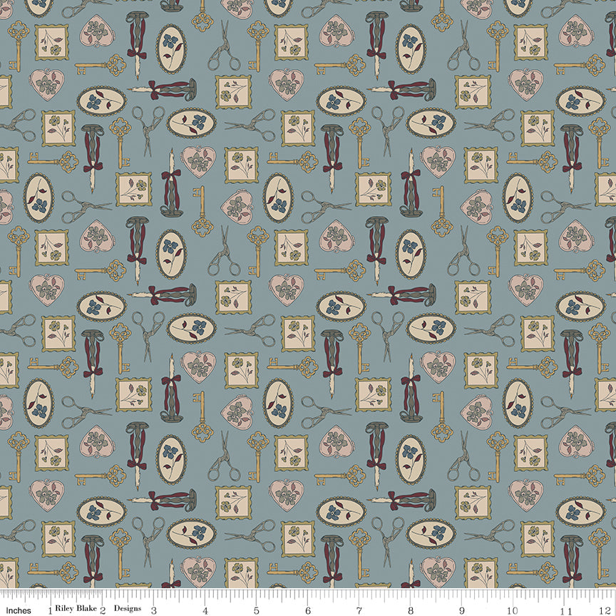 Charmed Storm fabric with golden keys, scissors, candlesticks, floral frames, and blush hearts on blue-gray with ruler for scale.