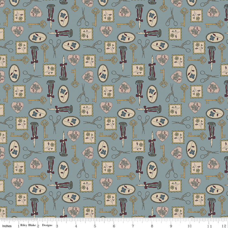 Charmed Storm fabric with golden keys, scissors, candlesticks, floral frames, and blush hearts on blue-gray with ruler for scale.
