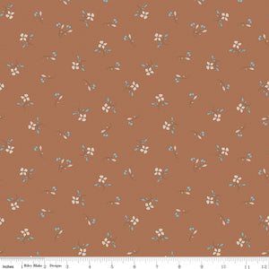 Iris Clay fabric with cream flowers, blue-gray leaves, and tiny buds scattered on warm terracotta with ruler for scale.