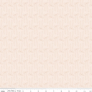 Bows Latte fabric with pale peach outlines of ribbon bows and trailing tails on creamy ivory with ruler for scale.