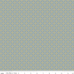 Stella Dove fabric with pale yellow four-petal flowers and an olive diamond lattice on blue-gray with ruler for scale.