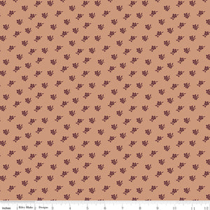 Magnolia Light Clay fabric with small burgundy flower and leaf sprigs scattered on muted peach with ruler for scale.
