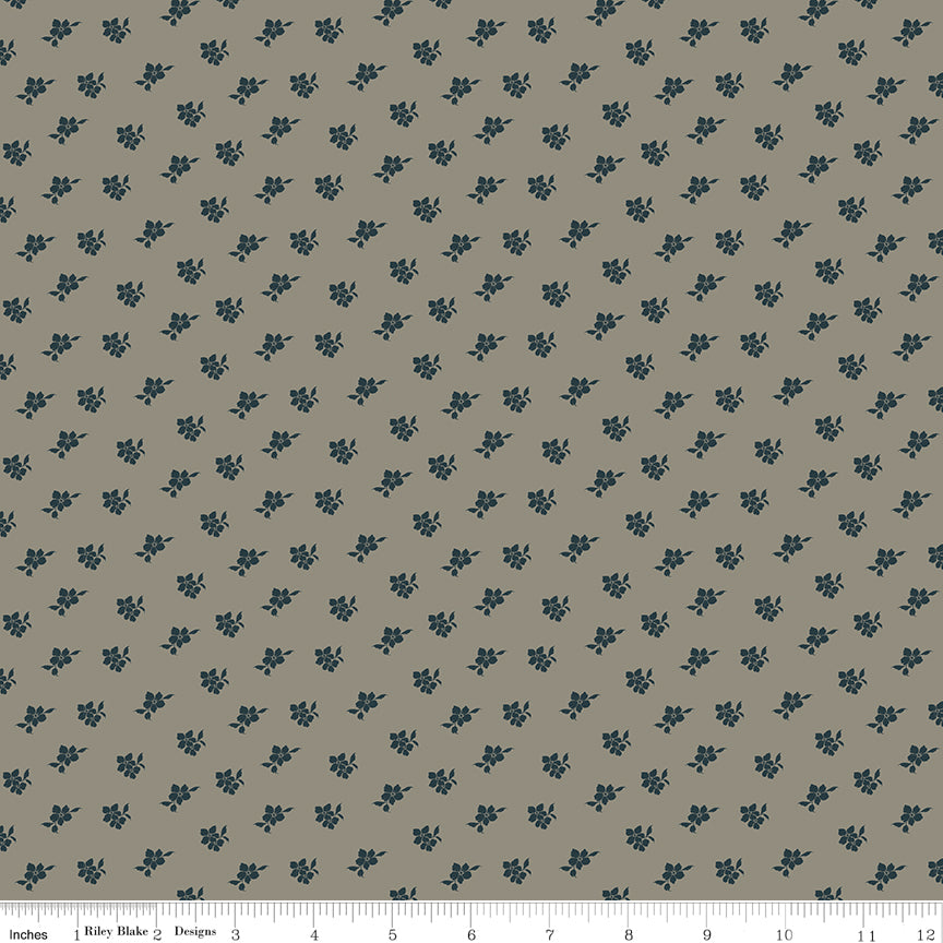 Magnolia Light Gray fabric with small charcoal-blue floral sprigs scattered across a warm gray background with ruler for scale.