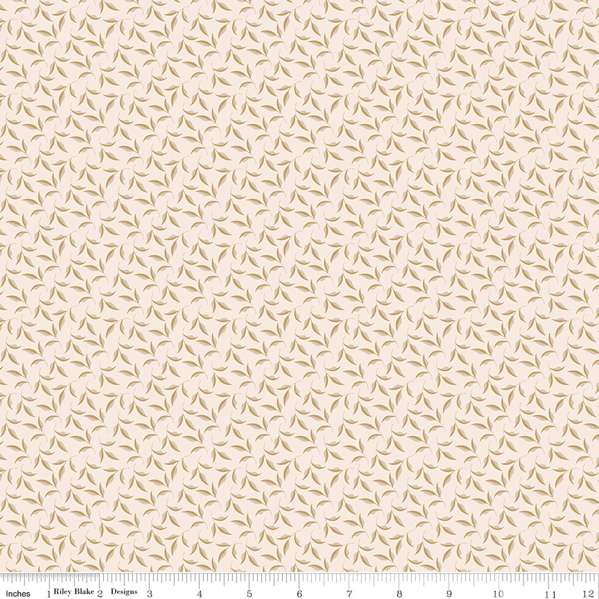 Evergreen Latte fabric with ochre and soft taupe leaves on curling stems across a creamy background with ruler for scale.