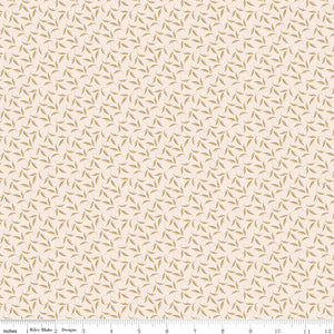 Evergreen Latte fabric with ochre and soft taupe leaves on curling stems across a creamy background with ruler for scale.