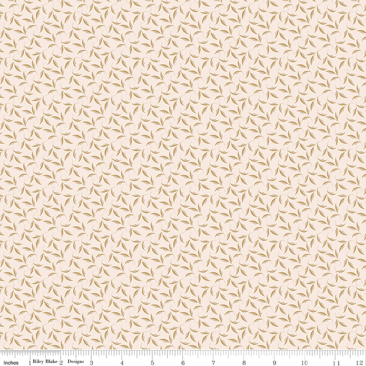 Evergreen Latte fabric with ochre and soft taupe leaves on curling stems across a creamy background with ruler for scale.