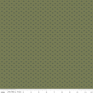 Lottie Green fabric with tiny slate-blue leaf sprigs and dots arranged in rows on muted olive green with ruler for scale.