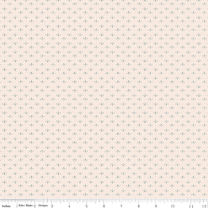 Lottie Latte fabric with tiny blue-gray leaf sprigs and dots in alternating rows on creamy ivory with ruler for scale.
