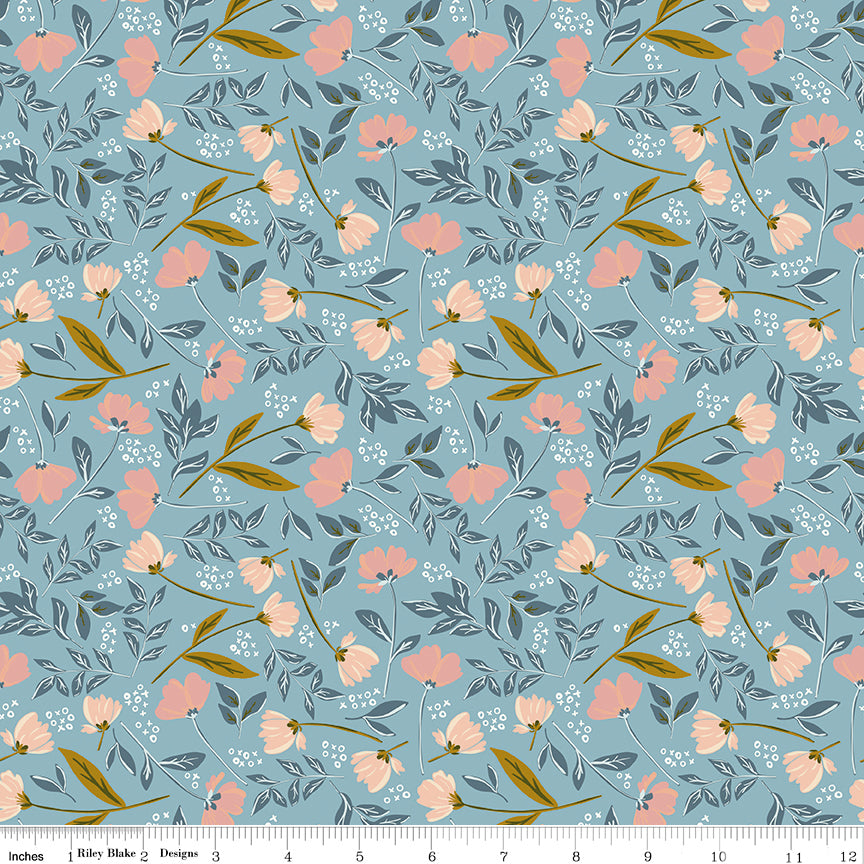 Main Dream floral fabric featuring soft pink and peach flowers, slate-blue foliage, and golden stems on a muted blue background with ruler for scale.