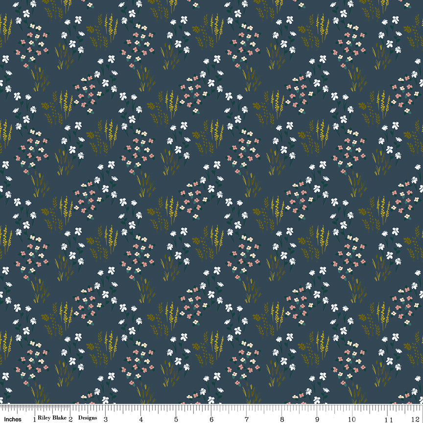Meadow Blue fabric with white and blush flowers, green leaves, and golden grasses on dark slate blue with ruler for scale.