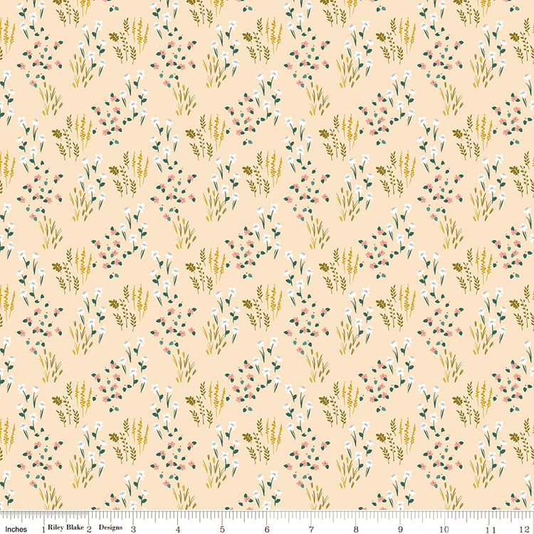 Meadow Blush fabric with white and pink wildflowers, green leaves, and golden sprigs on pale peach with ruler for scale.