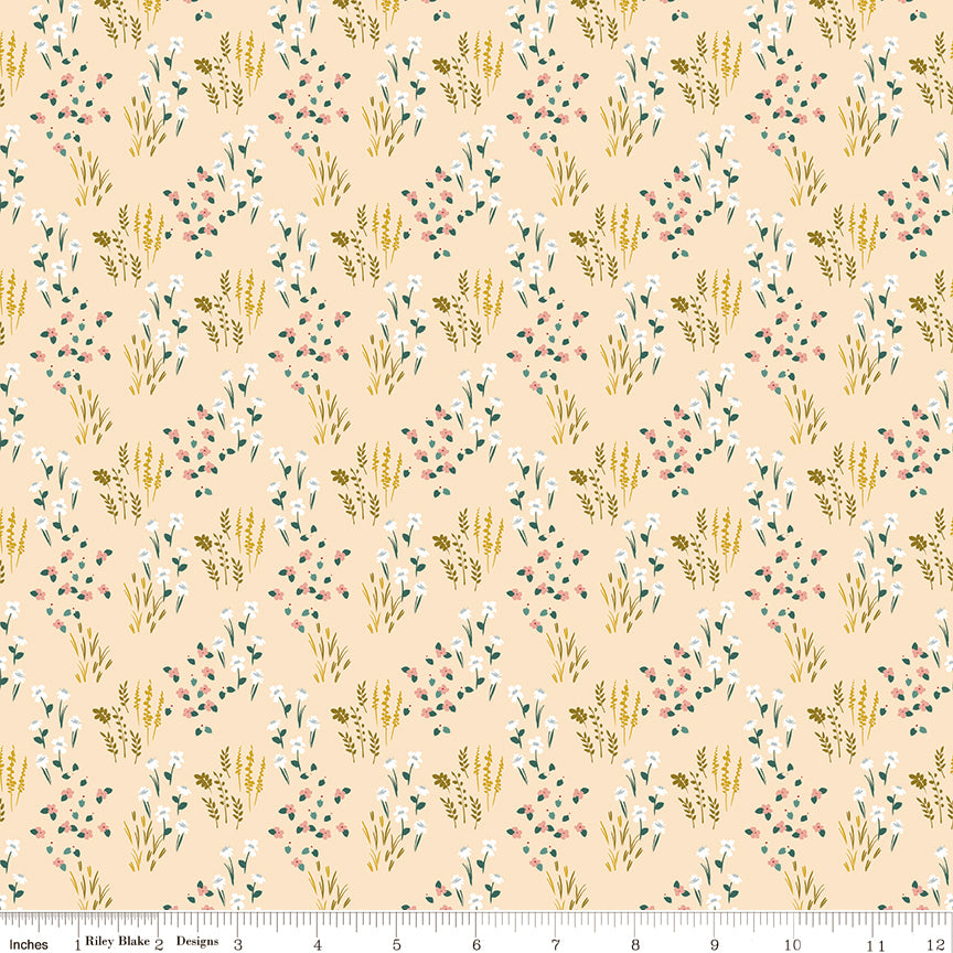 Meadow Blush fabric with white and pink wildflowers, green leaves, and golden sprigs on pale peach with ruler for scale.