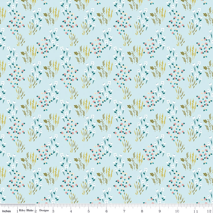 Meadow Powder fabric with white, pink, and cream flowers, teal leaves, and golden grasses on light blue with ruler for scale.