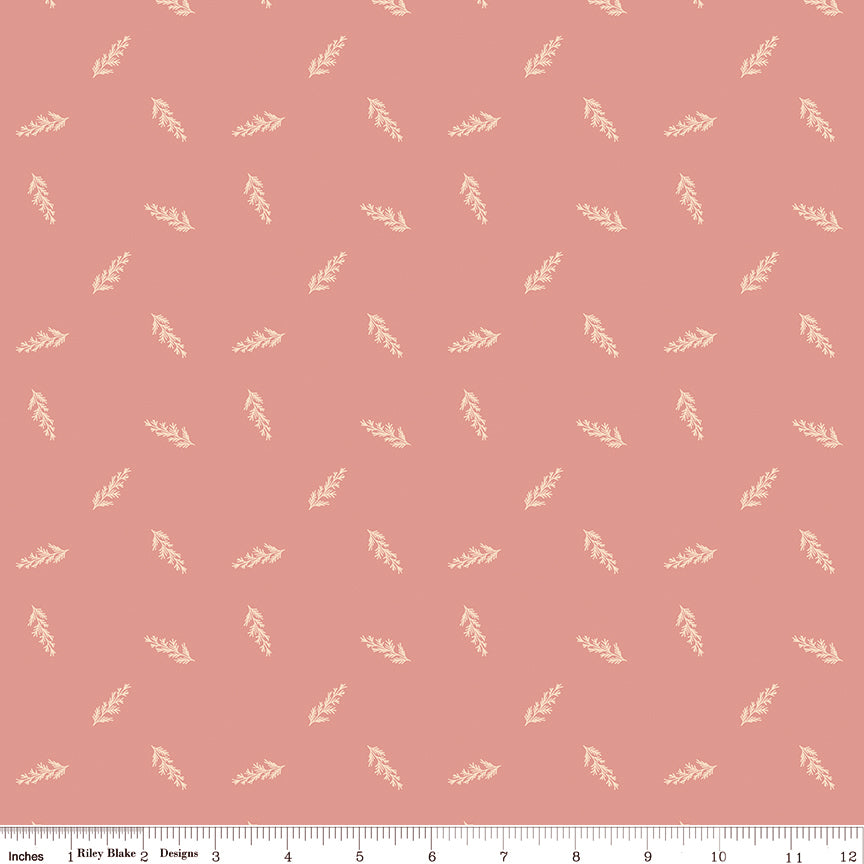 Toss Coral fabric with small cream leafy sprigs tossed across a muted coral-pink background with ruler for scale.