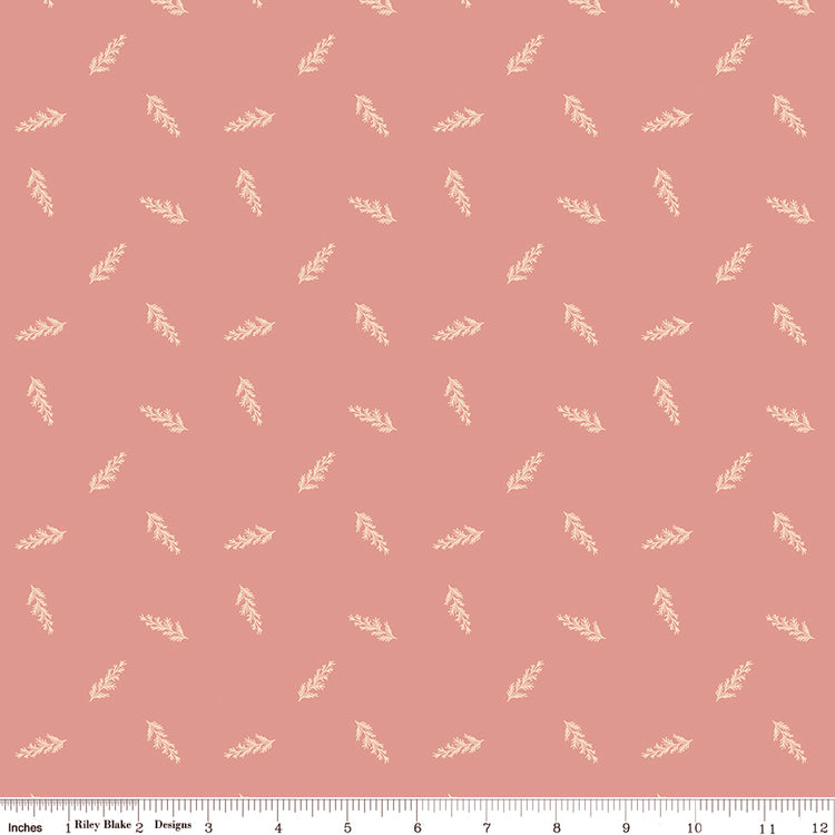 Toss Coral fabric with small cream leafy sprigs tossed across a muted coral-pink background with ruler for scale.