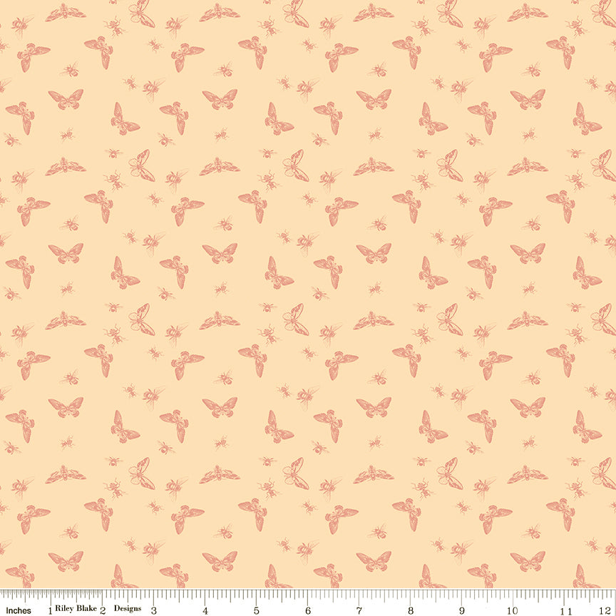 Flutter Blush fabric with coral butterflies, moths, bees, and other insects on a pale peach background with ruler for scale.