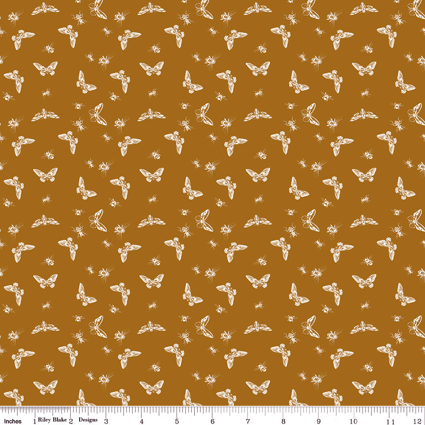 Flutter Butterscotch fabric with cream butterflies, moths, and small insects on a golden ochre background with ruler for scale.