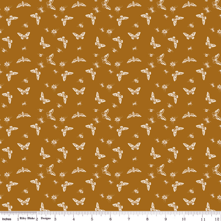 Flutter Butterscotch fabric with cream butterflies, moths, and small insects on a golden ochre background with ruler for scale.