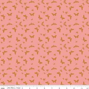 Flutter Coral fabric with golden ochre butterflies, moths, and small insects on a coral-pink background with ruler for scale.