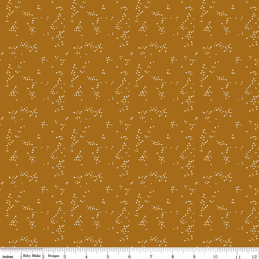 Hearts Butterscotch fabric with small cream hearts in scattered clusters on a warm golden ochre background with ruler for scale.