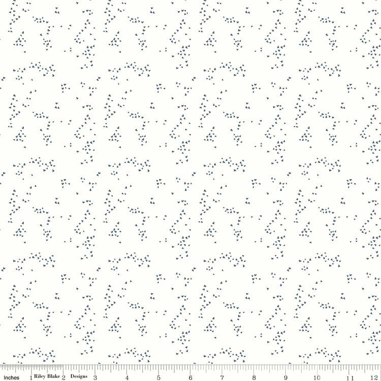 Hearts Off White fabric with tiny slate-blue hearts scattered in irregular clusters on an off-white background with ruler for scale.