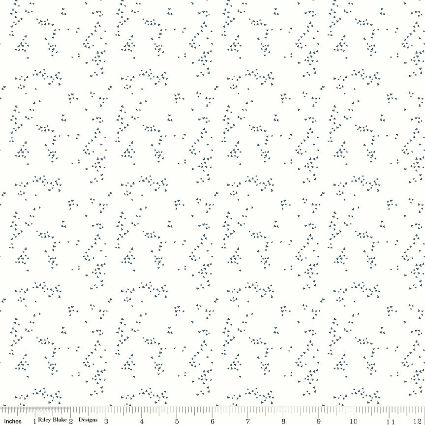 Hearts Off White fabric with tiny slate-blue hearts scattered in irregular clusters on an off-white background with ruler for scale.