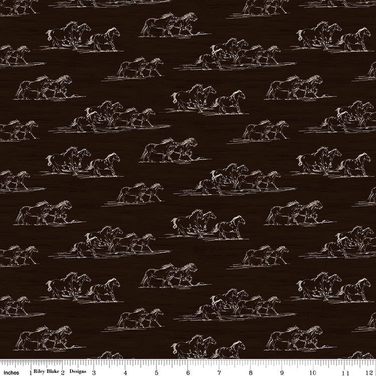 Horse Toile Brown fabric with cream line drawings of running horses on a dark brown background with ruler for scale.
