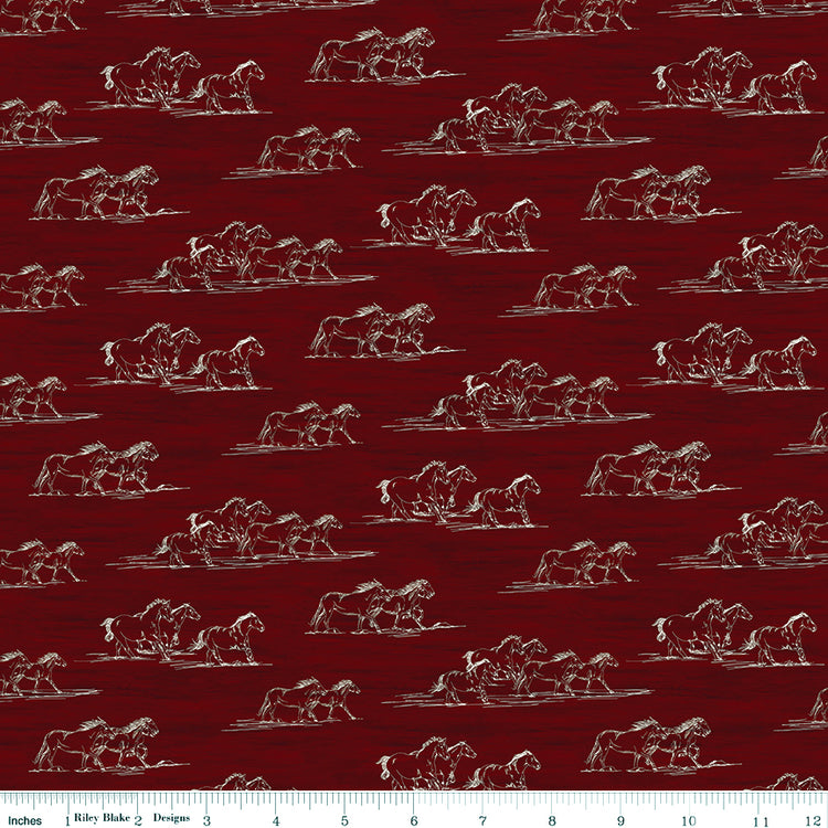 Horse Toile Red fabric with cream sketches of galloping horses on a deep red background with ruler for scale.