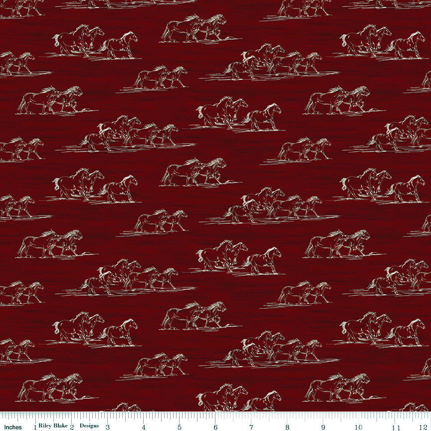 Horse Toile Red fabric with cream sketches of galloping horses on a deep red background with ruler for scale.