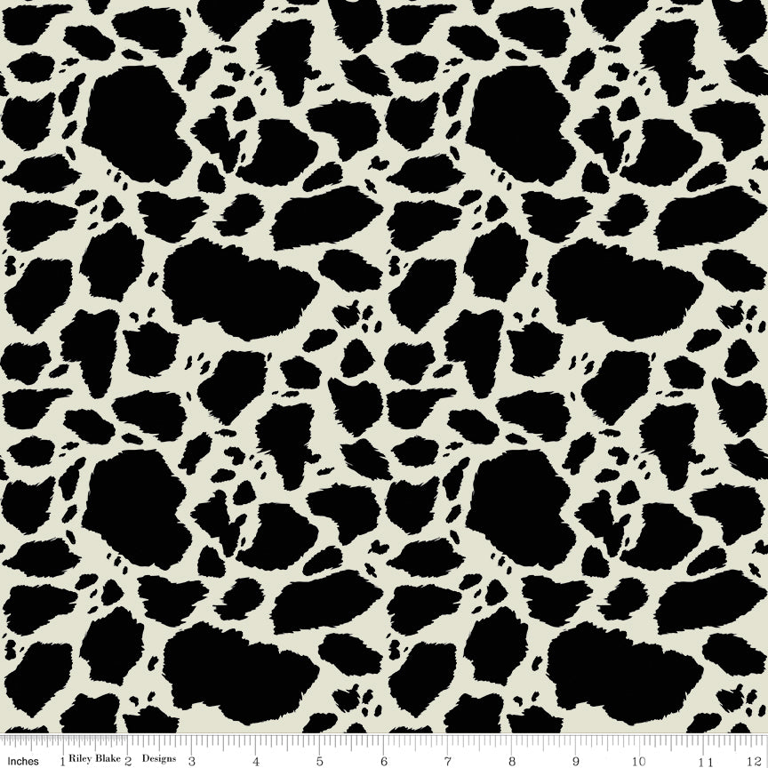 Cow Patches Black fabric with irregular black cowhide-style spots on a creamy off-white background with ruler for scale.