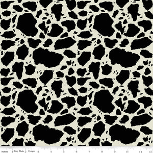 Cow Patches Black fabric with irregular black cowhide-style spots on a creamy off-white background with ruler for scale.