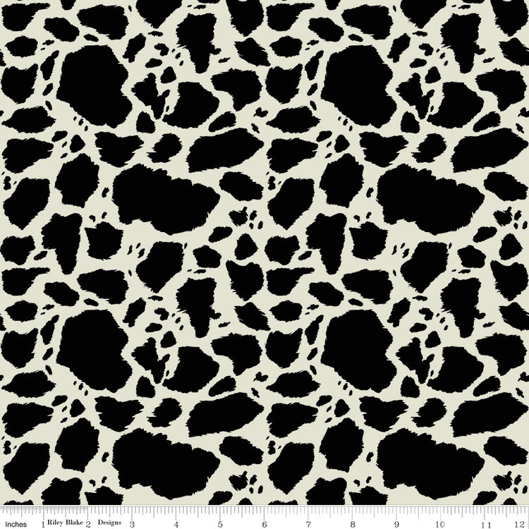 Cow Patches Black fabric with irregular black cowhide-style spots on a creamy off-white background with ruler for scale.