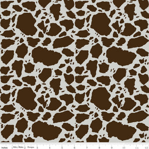 Cow Patches Brown fabric with chocolate brown cowhide-style markings on an off-white background with ruler for scale.