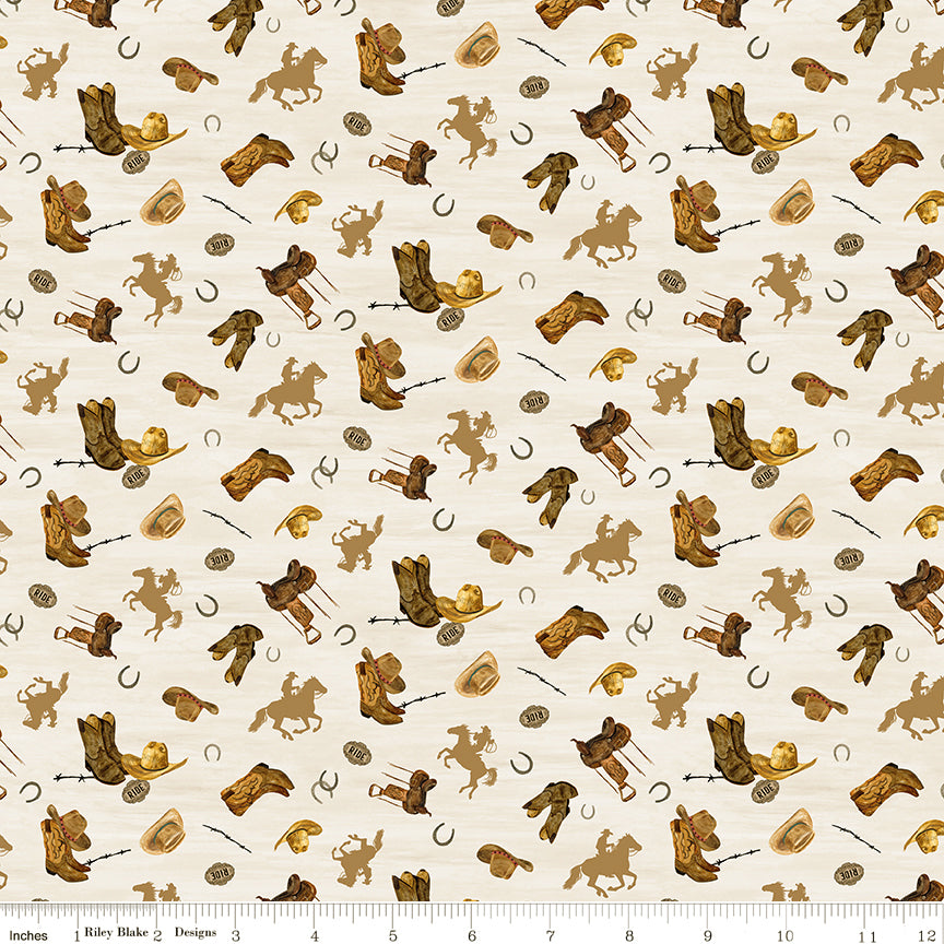 Icon Toss Cream fabric with boots, hats, saddles, horseshoes, and golden horseback riders on cream with ruler for scale.