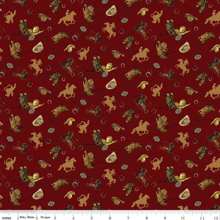 Icon Toss Red fabric with cowboy hats, boots, saddles, horseshoes, and golden horseback riders on deep red with ruler for scale.