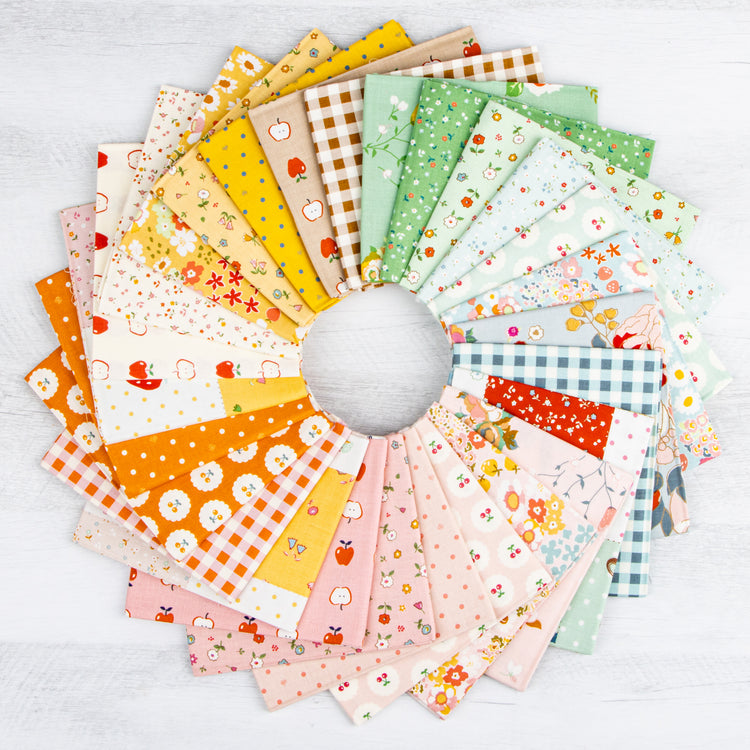 Cotton Nook fabric collection arranged in a colorful fan of florals, fruit, dots and ginghams.